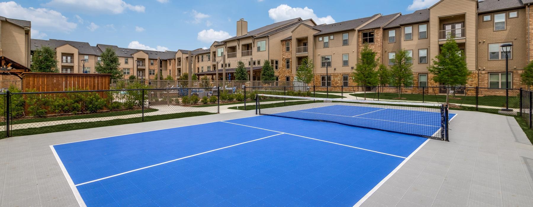 a tennis court with a building in the background