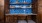 a blue tiled wall and brown cabinets