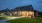 a home on a lawn with evening lights on