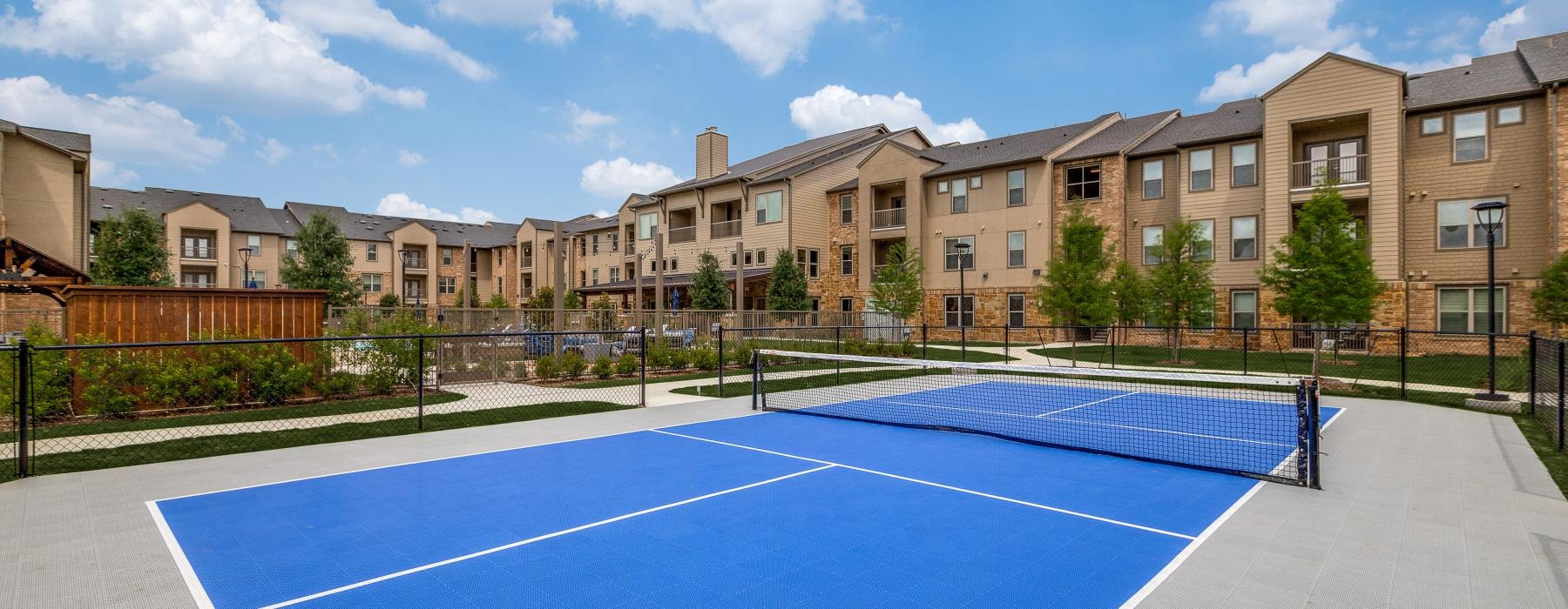 a tennis court with a building in the background