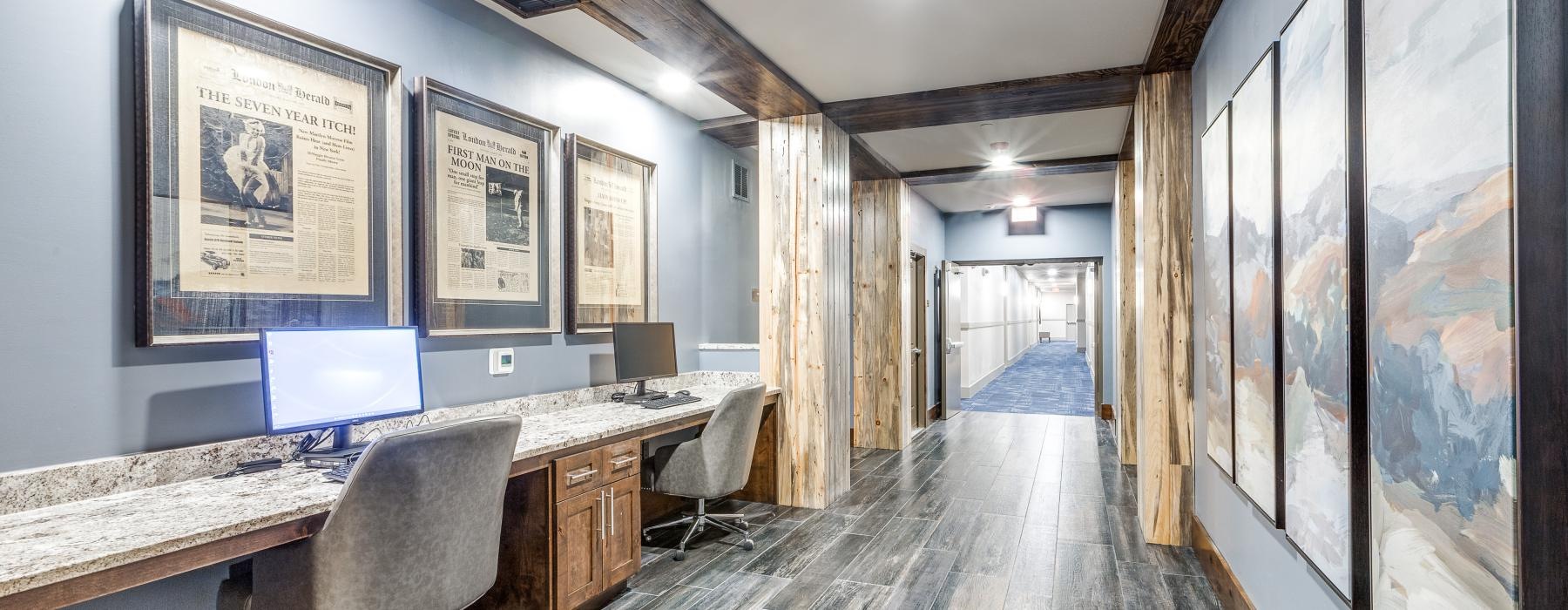 a long hallway with a desk and chairs